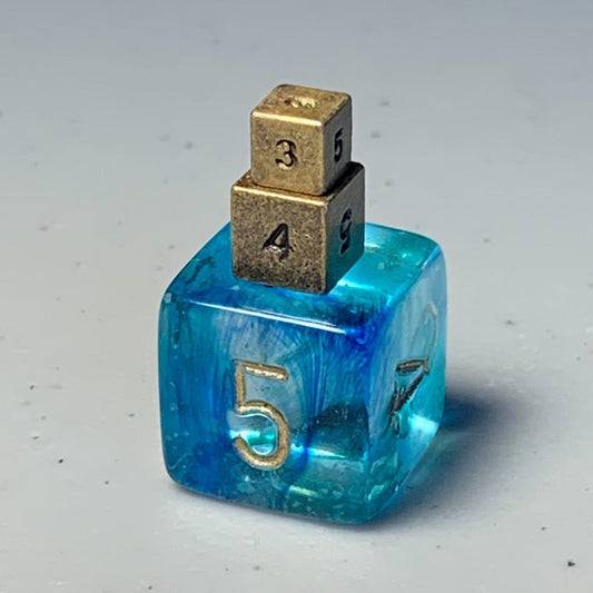 5mm and 6.5mm Antique Gold metal D6s stacked on top of a 16mm Nebula Oceanic D6